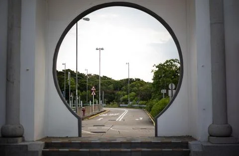 Circular gate view of an empty asphalt road leading into a lush green forest Stock Photos