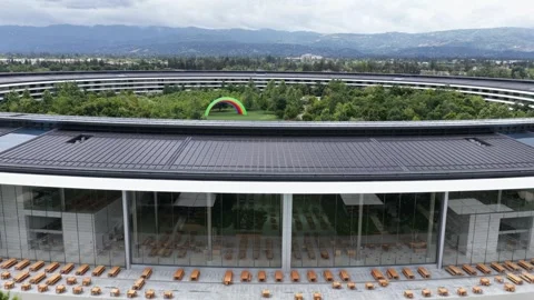 Circular glass headquarters ring rises above Cupertino, California apple Stock Footage 339143277