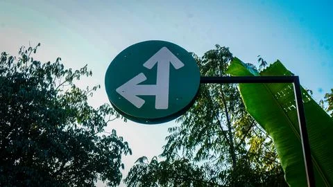 Circular Green Directional Road Sign with Two White Arrows Stock Photos
