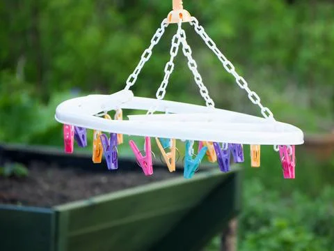 A circular hanging close drying device with multiple colourful pegs Stock Photos