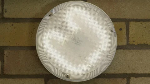 Circular light hung on an interior brick wall, being switched on then off. Stock Footage 143457648