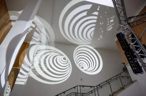 Circular light patterns projected on wall in modern interior space Stock Photos