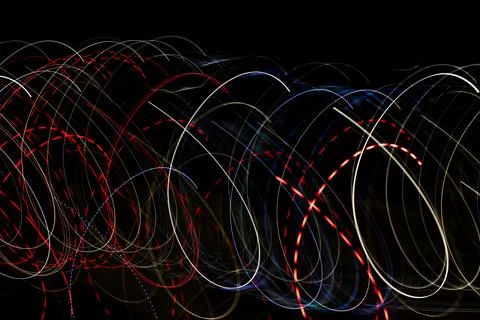 Circular light trails at night create neon loops and dotted bokeh suggesting  Stock Photos