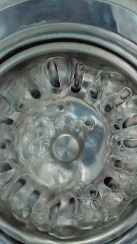 Circular metal drain filter with flowing water and reflective industrial texture Video stock 344968921