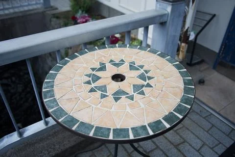Circular mosaic table with geometric star pattern on balcony Stock Photos
