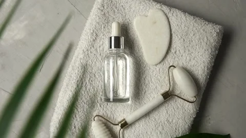 Circular motion of face roller and guasha massager with tropical palm leaves Stock Footage 225775371