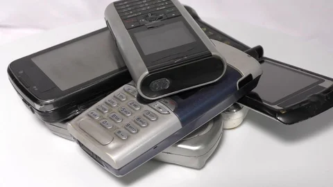 Circular motion of pile of old mobiles on white surface Stock Footage 111887866