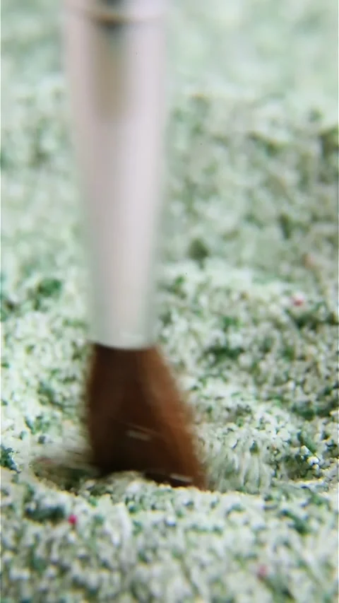 With circular movements, the brush is moved over a colored powdery material. Video stock 246906323