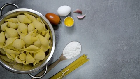 Circular moving drainer with Conchiglie pasta. Gray background with kitchen d Stock Footage 113595542