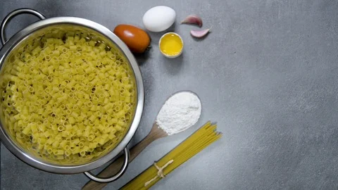 Circular moving drainer with pasta. Gray background with kitchen details. Top Stock Footage 113632725