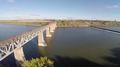 Circular pan aerial shot of a train traveling across a bridge Stock Footage 43314419