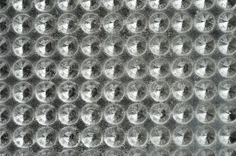 Circular patterns on textured surface reflect light abstractly Foto stock