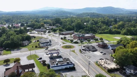 Circular roundabout anchors small Amherst town center, gas station and brick Stock Footage 345727676