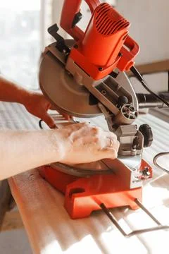 Circular saw in action as a carpenter skillfully cuts wooden planks. Hands hold Stock Photos