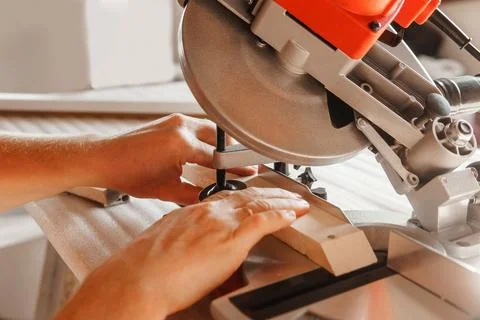 Circular saw in action as a carpenter skillfully cuts wooden planks. Hands hold Stock Photos