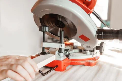 Circular saw in action as a carpenter skillfully cuts wooden planks. Hands hold Stock Photos