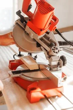 Circular saw in action as a carpenter skillfully cuts wooden planks. Hands hold Stock-Fotos