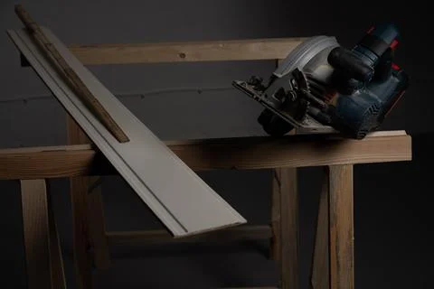 Circular saw and guide rail setup on wooden board for DIY woodworking project Stock Photos