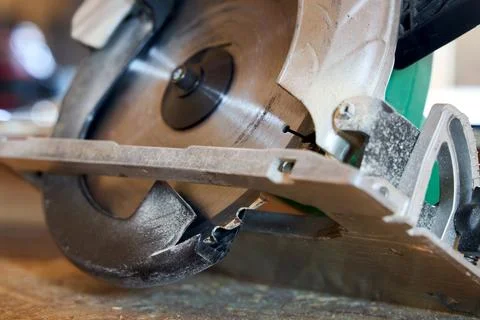Circular saw close up with sharp metal blade on wooden workbench workshop. Po Stock Photos