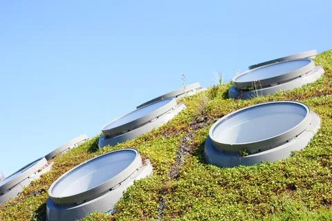 Circular shaped skylights on a undulating grass surface, in the background .. Foto stock