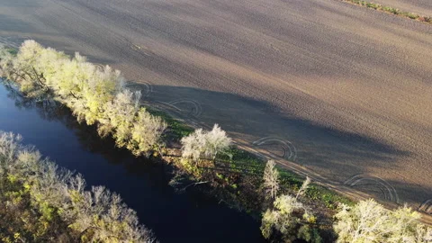 Circular shapes on empty agricultural field next to a river viewed from drone Stock Footage 263201085