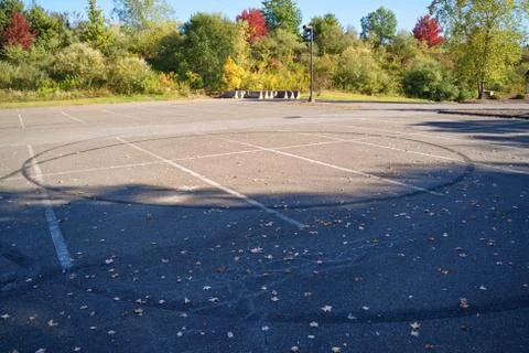 Circular skid marks on an empty parking lot is evident of young people reckle Stock Photos
