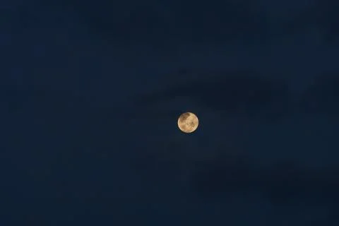 Circular small red moon high in sky on black background with copy-space, mo.. Stock Photos