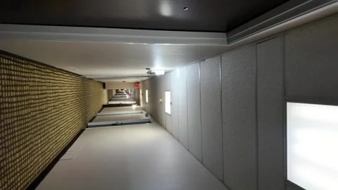 Circular Spin Through a Hotel Corridor With Ceiling Lights Overhead Stock Footage 288902264