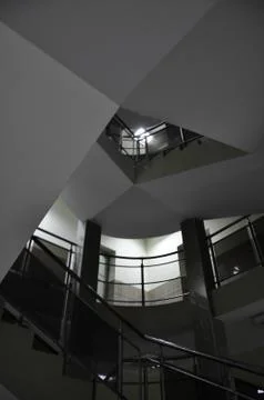 Circular staircase. Geometry. Sharp triangular ceiling shape. Square tiles on Stock Photos