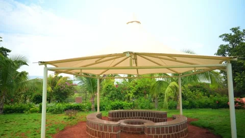 Circular stone bench sits under canopy in tropical garden Stock Footage 304848156