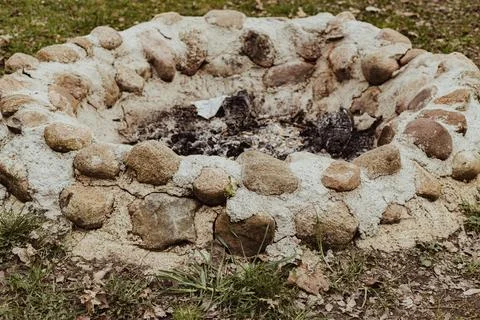 Circular stone fire pit constructed from natural stones and mortar, surroun.. Stock Photos
