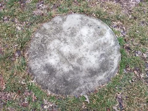 Circular stone or cement on ground with grass Stock Photos