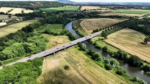 Circular tracking shot of a road bridge and river in a rural surrounding Stock Footage 246998402