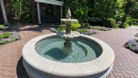 Circular walking shot framing garden fountain Stock Footage 239101703