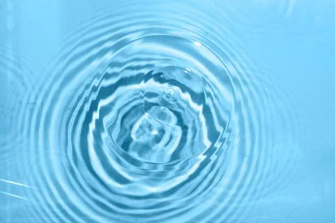 Circular water ripple pattern on blue surface abstract liquid texture purity  Stock Photos