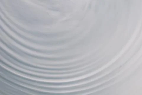 Circular wave motion in a fluid system. blue gray background for a liquid pus Stock Photos