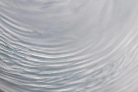 Circular wave motion in a fluid system. blue gray background for a liquid pus Stock Photos