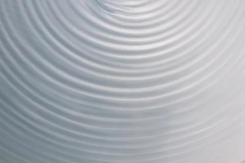 Circular wave motion in a fluid system. blue gray background for a liquid pus Stock Photos