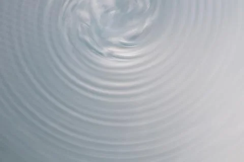 Circular wave motion in a fluid system. blue gray background for a liquid pus Stock Photos