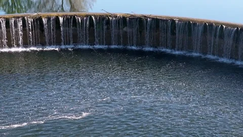 Circular weir on lippe river generating smooth waterfall cascading Stock Footage 309802049
