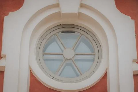 Circular window with six-pane design set in an ornate archway against a tex.. Stock Photos