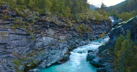 Circulating aerial shot of a turquoise mountain stream Stock Footage 210538009