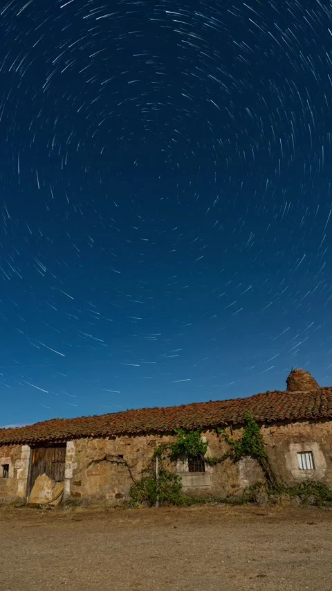 Circumpolar star trails rotating over abandoned farmhouse Stock Footage 329037089