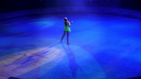 A circus artist performs in the circus arena with a lot of hula hoops, creates a Stock Footage 168922444