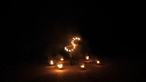 A circus artist performs a fire dance in the darkness, slow motion. Fire show. Stock Footage 294334635