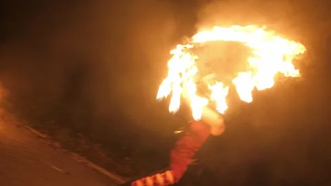 A circus artist performs a fire dance in the darkness, slow motion. Fire show. Stock Footage 295189947