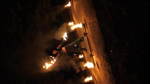 A circus artist performs a fire dance in the darkness, slow motion. Fire show. Stock Footage 297355517