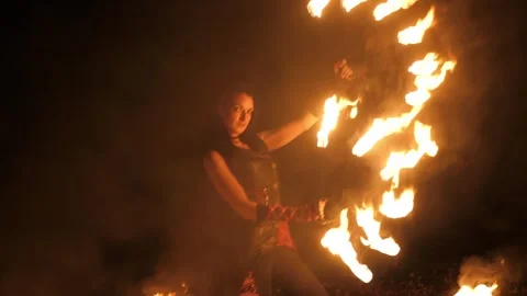 A circus artist performs a fire dance in the darkness, slow motion. Fire show. Stock Footage 317298933
