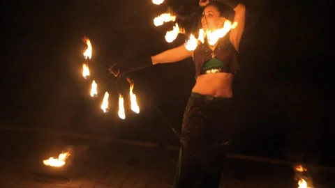 A circus artist performs a fire dance in the darkness, slow motion. Fire show. Stock Footage 317931608