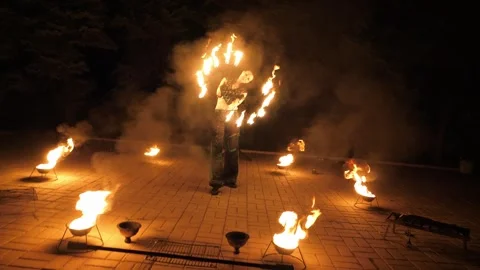 A circus artist performs a fire dance in the darkness, slow motion. Fire show. Stock Footage 319004382